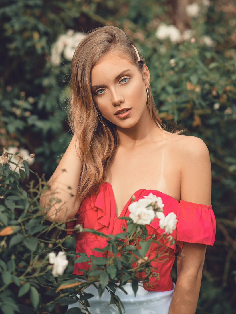 Renato-Abati-woman-behind-flowers-in-red-off-shoulder-top-3434862-Original-Cropped.png